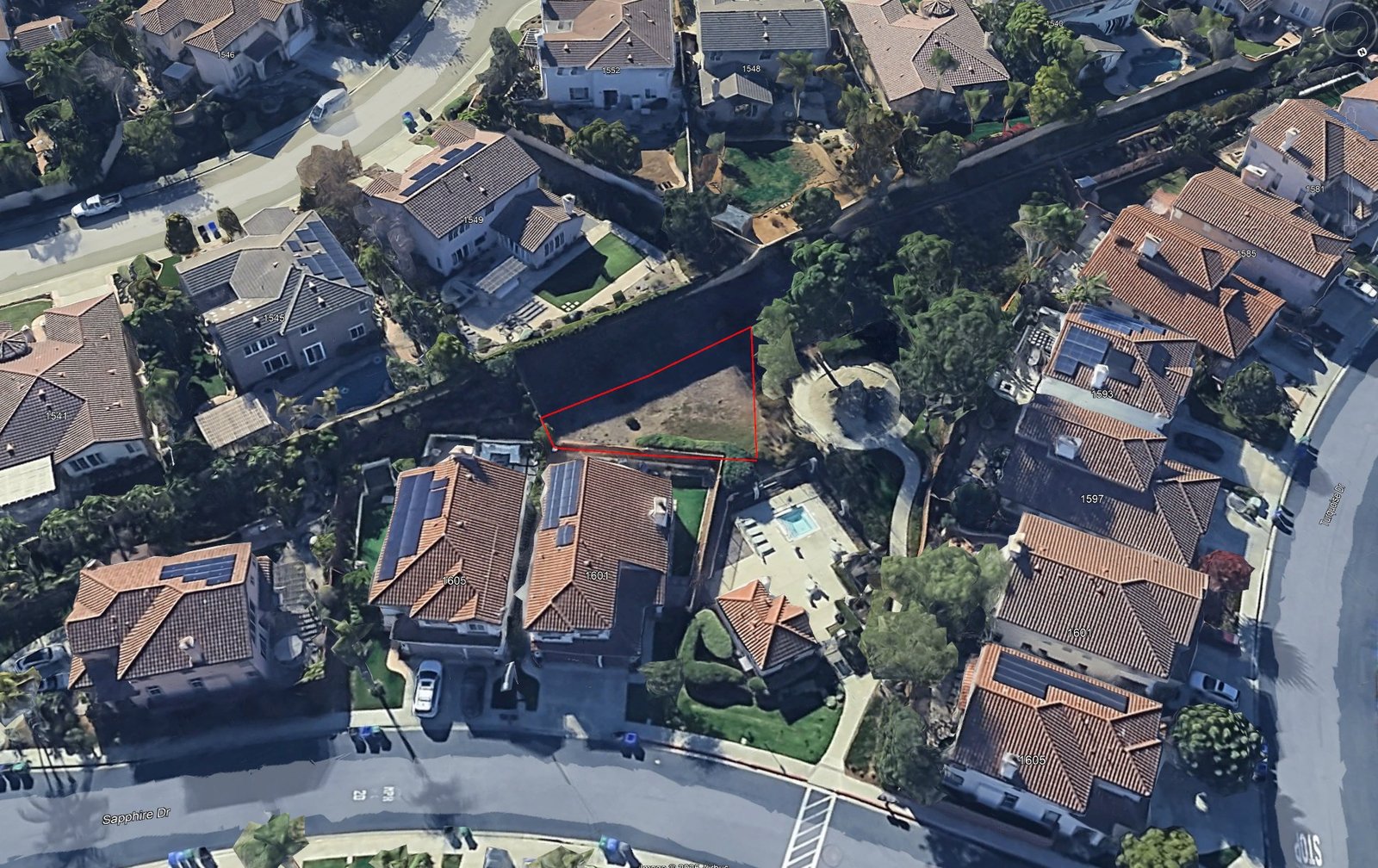 Aerial view of the proposed garden site with the trapezoidal lot outlined in red